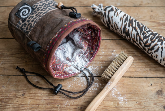 Open climbing chalk bag with visible chalk dust next to a Shoe Sausage deodoriser sachet